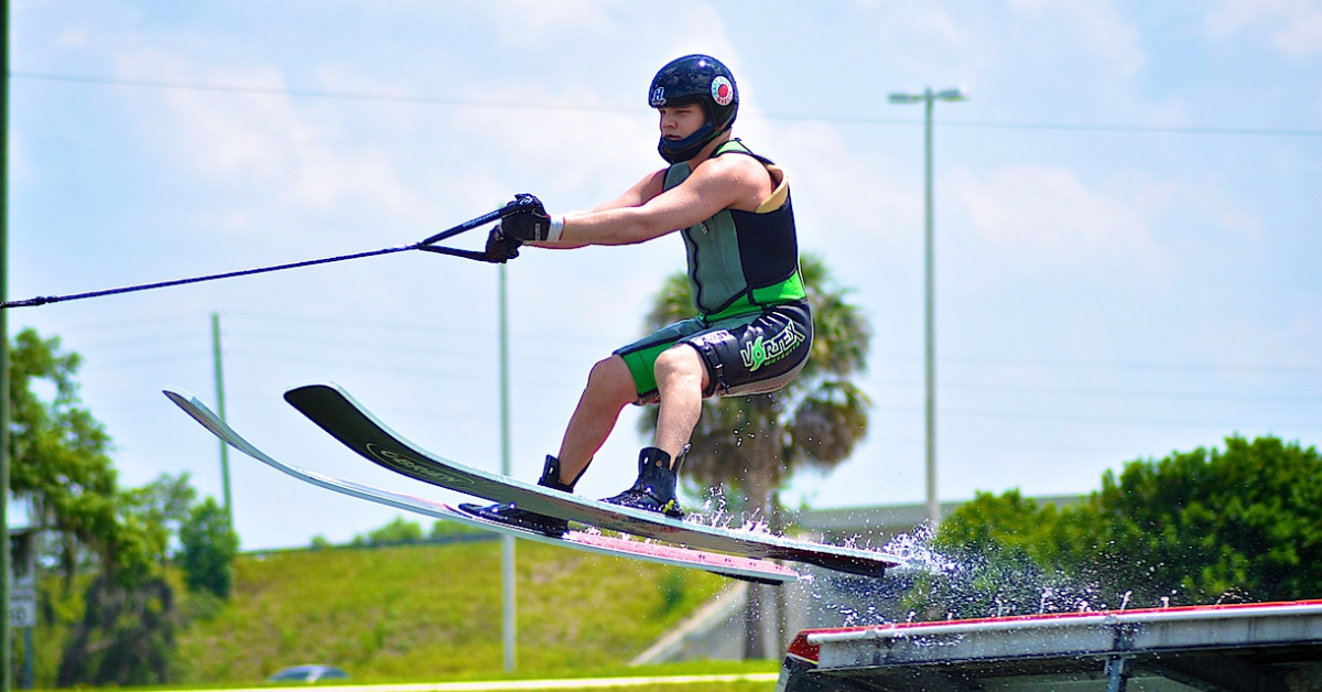 Wearing a helmet, Ryan Riehl is pulled over a jump by a boat while on waterskis.